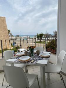CampomarinoA 100metri dal mare difronte alla torre saracena.的一张带白色椅子的桌子,享有海景