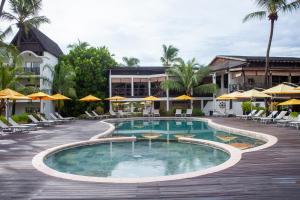 阿姆巴托洛阿卡皇家海滩酒店的度假村的游泳池,配有椅子和遮阳伞