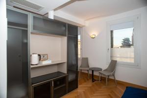 帕多瓦Padova Suites C20的客房设有桌椅和窗户。