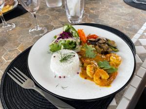 MamoudzouLe Passamainty Lodge的餐桌上放着一盘饭和蔬菜的食物
