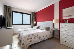 拉克鲁斯Trevina 31-2的一间卧室设有一张床和红色的墙壁
