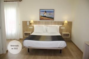 穆希亚Hotel Playa de Lago的卧室配有带白色枕头的大床