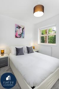 利物浦FLATZY - Quiet Sefton Park Luxury Apartment的卧室设有一张白色大床和一扇窗户。