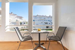 福恩吉罗拉Luxury 3 bed apartment Torreblanca的阳台享有建筑景致,配有桌椅。