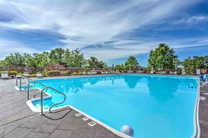 布兰森Branson Resort Condo with Scenic Patio and Pool Access的一个带椅子和树木的大型蓝色游泳池