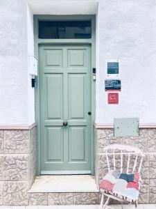 CaudielVillabett Caudiel está de moda的白色建筑中带长凳的绿色门
