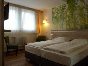 圣安德里斯伯格Berghotel Glockenberg的一间卧室设有两张床和大窗户