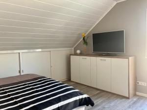 利塞尔Kalverkamp Ferienwohnung的一间卧室配有一张床和一台平面电视