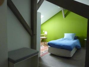 塔布Etage privatif的一间卧室设有一张床和绿色的墙壁