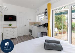 利物浦Flatzy - Charming Garden Annexe in Aigburth with Kitchenette的一间带白色床的卧室和一间厨房