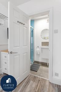 利物浦Flatzy - Charming Garden Annexe in Aigburth with Kitchenette的浴室设有白色门和镜子