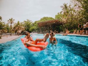 伯里塔卡Viajero Tayrona Hostel & Ecohabs的一群人在度假村的游泳池里