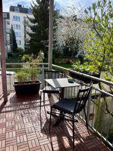 亚琛Zentrale Ferienwohnung mit Balkon in Aachen的阳台的天井配有桌椅