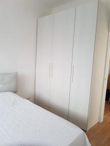 塔兰托ETRA Casa Vacanza的一间白色卧室,配有一张床和两个高大的橱柜