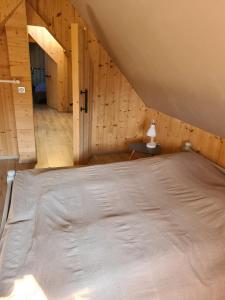克吕特Le chalet du bois joli的木天花板的客房内的一张床位