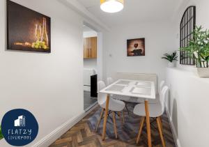 利物浦FLATZY - Modern Apartment Close to Football Stadiums的一间配备有白色桌椅的用餐室