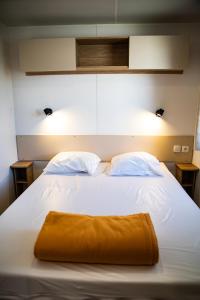 鲁西隆地区卡内amorosa mobil home的一张白色的大床,上面有橙色毛巾