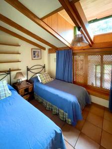 FirgasCasa Rural en medio del bosque, El Lance的一间卧室设有两张床,其中设有窗户。