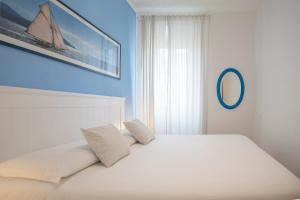 费拉约港La Petite Maison的一张白色的床,上面有两个枕头