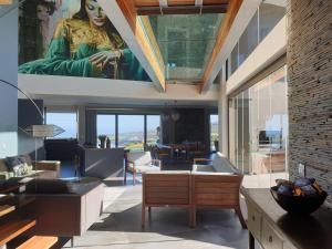莫塞尔湾Luxury Home located on Pinnacle Point Golf Estate的客厅里有一幅大幅画画,画着一位女人