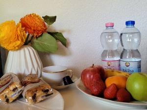卢塞恩Villa Castagna Guesthouse的一张桌子,上面放着一盘水果和两瓶水