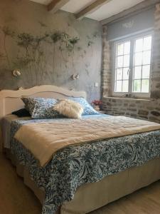 Ménil-Hubert-sur-Orne"La chambre des TISSERANDS"的一间卧室配有一张带蓝色枕头的大床