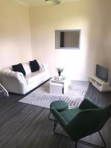 格拉斯哥Vogue Apartments的客厅配有白色沙发和电视