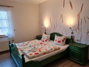 米德尔哈根莫彻古特瑞汉斯酒店的一间卧室配有一张带绿色床头板和枕头的床。