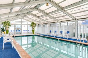 大洋城开曼套房酒店的一个带蓝色椅子和天花板的游泳池