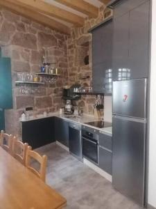 里瓦达维亚Casiña da Madalena的厨房配有不锈钢冰箱和桌子