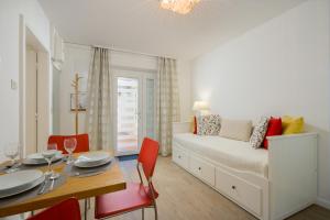 杜布罗夫尼克兹卡拉公寓的一间卧室配有一张床和一张桌子及红色椅子