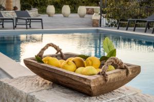 阿沃拉Masseria Bio - Agriturismo Villa Grazia的坐在游泳池旁的一只木柠檬