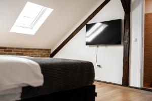 萨格勒布DreamHouse7 rooms的卧室配有一张床,墙上配有电视。
