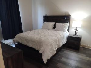 哈蒙德Villa 5的一间卧室配有一张带白色床单和灯的大床