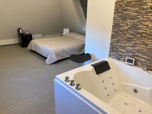 乌得勒支Wellness Suite Utrecht的一间带浴缸的浴室和一张位于客房内的床