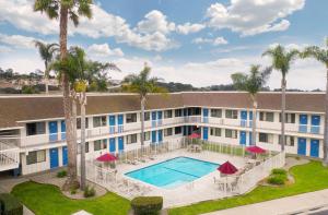 皮斯莫比奇庇斯摩海滩6号汽车旅馆的公寓大楼设有游泳池和棕榈树