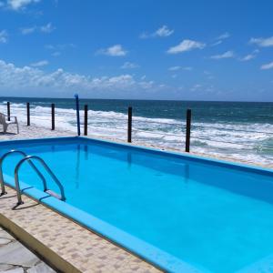 拉巴拉德纳圣米格尔Casa em condomínio, beira mar e piscina Barra de São Miguel - Maceió- AL的海滩背景游泳池