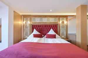 福森路德维格酒店的一间卧室配有一张大床和红色床头板