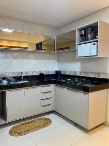 杰里科科拉Acoara PRAIA的厨房配有白色橱柜和黑色台面
