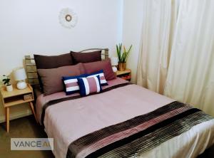 卡尔古利2BR luxury house in Piccadilly的一间卧室配有一张带色彩缤纷枕头的大床