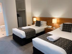 布罗肯希尔红地球汽车旅馆 的酒店客房,设有两张床和一盏灯