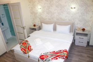 塔什干Hotel Taht的卧室配有一张带白色床单和枕头的大床。