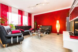 科隆科隆展览公寓的客厅设有红色的墙壁和黑色皮革家具