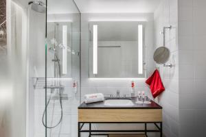 多特蒙德IntercityHotel Dortmund的浴室配有盥洗盆和带镜子的淋浴