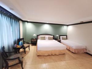 大雅台大雅台乡村酒店的一间卧室配有两张床、一张桌子和一把椅子