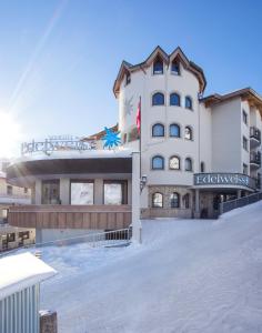 索尔登Hotel Edelweiss Hochsölden Superior的大楼前的雪地里的酒店