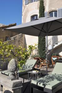 Châteauneuf-de-Gadagne小城堡住宿加早餐旅馆的一个带桌子和遮阳伞的庭院