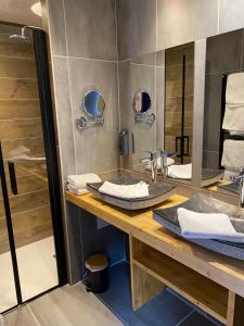 昂塞勒Hôtel Restaurant & Spa Les Autanes的一间带两个盥洗盆和淋浴的浴室