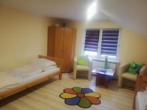 奥古斯图Kwatera Na Rogu的一间卧室配有一张床、两把椅子和一个窗户