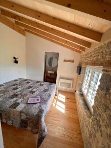Saint-Martin-LalandeLE MOULIN DU VIVIER的一间卧室设有一张床和石墙
